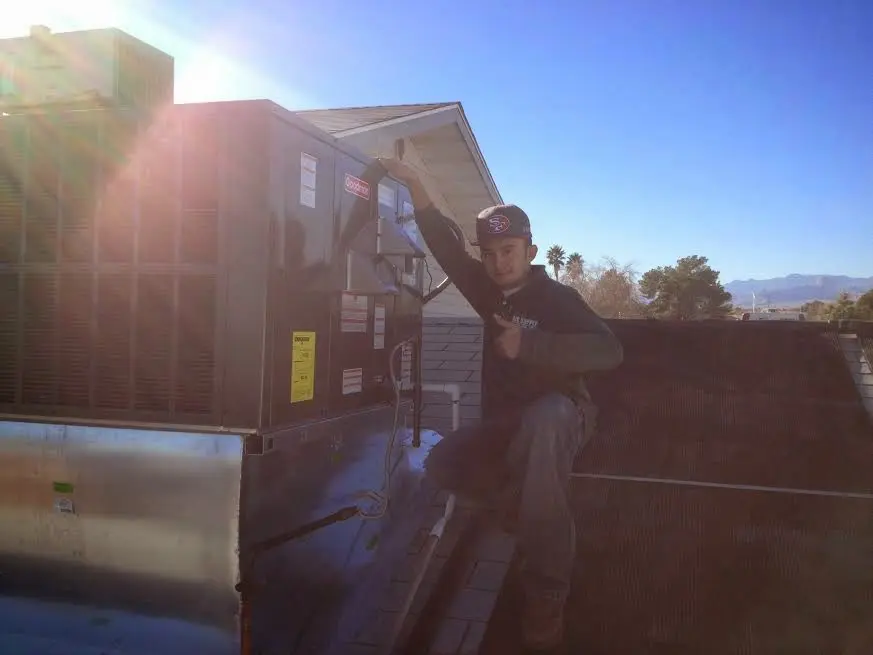 HVAC technician performing Boiler Repair on a rooftop unit in Tuscumbia